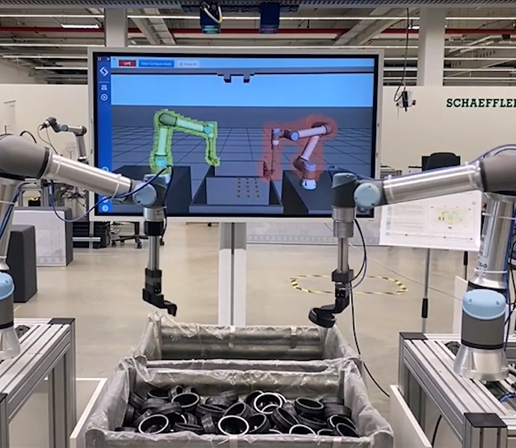 Two robots with realtime robotics software on screen in background
